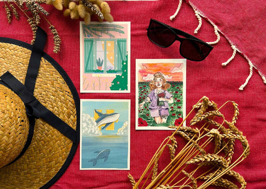 3 cartes postales illustrées sur le thème de l'été, femme dans champ de coquelicot, chat qui dort au bord d'une fenêtre avec glycine, baleine sur ciel bleu dan l'océan avec pièce de puzzle